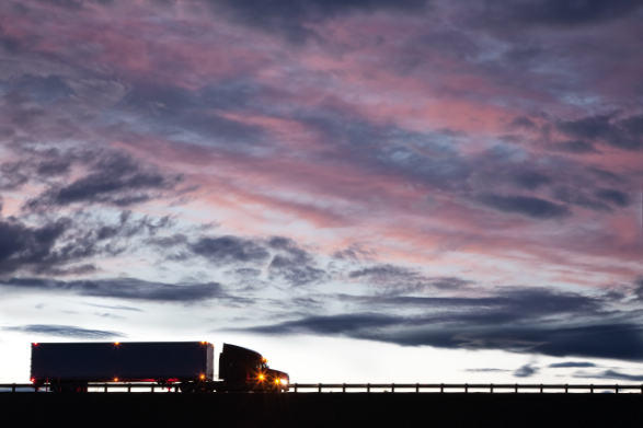 Silhouette of Commercial Truck Driving on Road