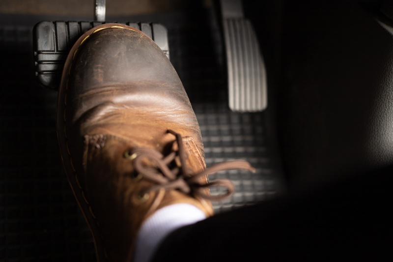 close up of truck driver putting their foot on the brakes