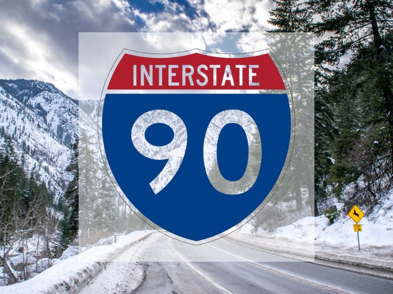 I-90 road sign with snowy mountain road background