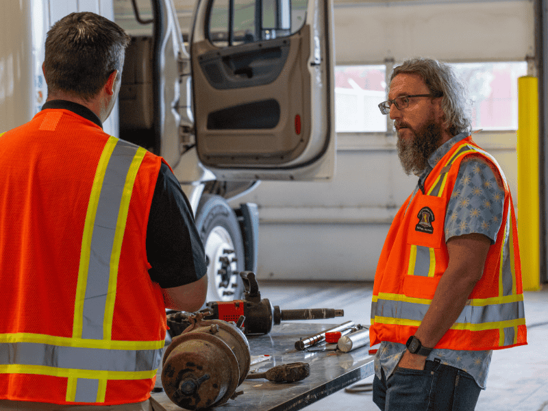 Laurence Stinson wearing safety vest while speaking with instructor at continuing education course