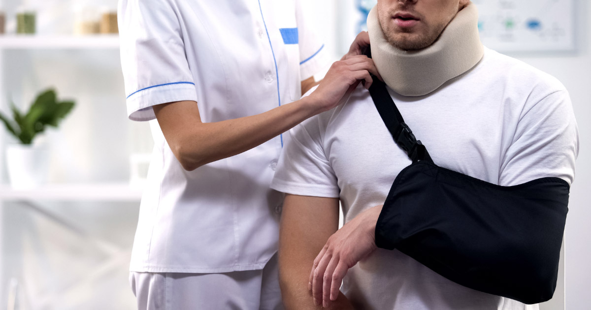 Medical professional placing brace on man wearing sling