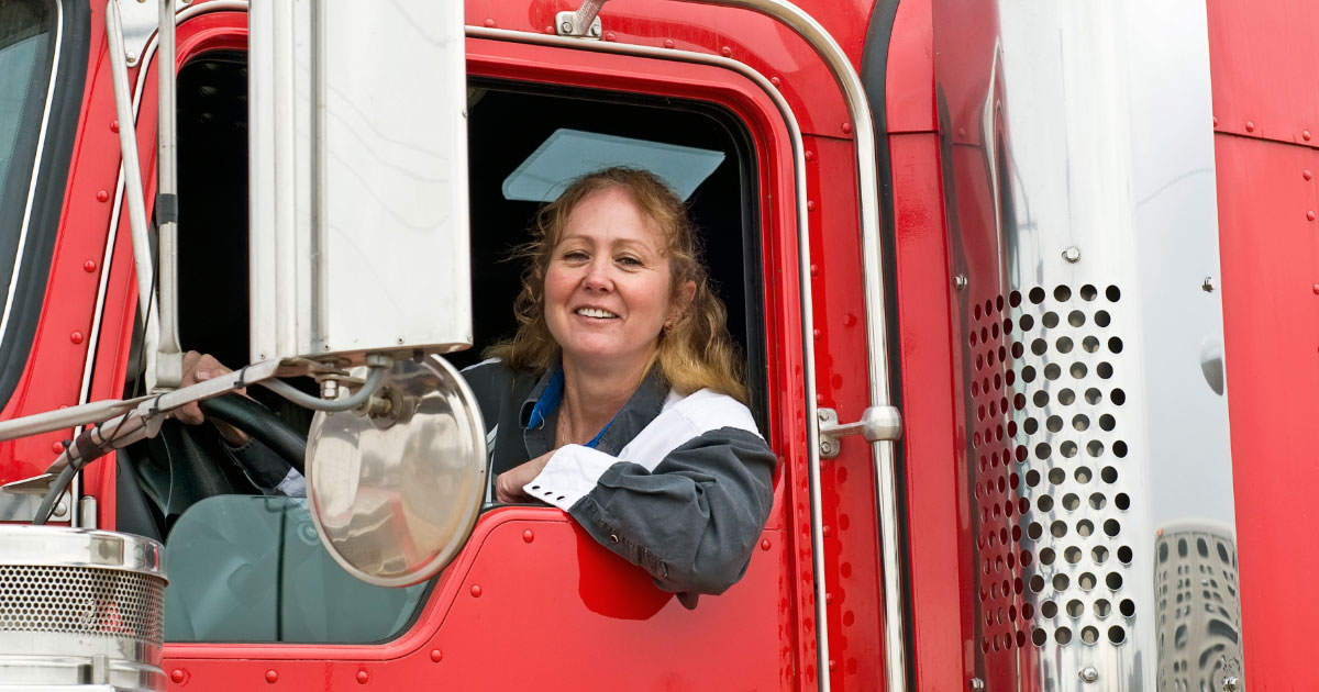 Woman driving large red semi-truck