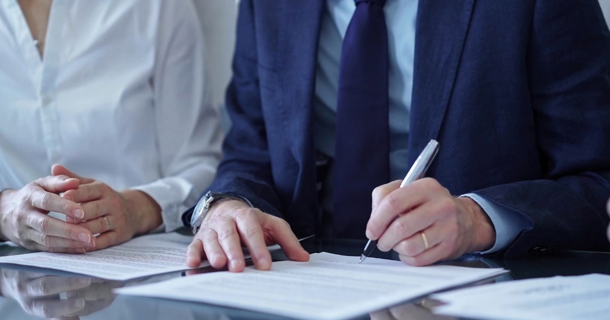 Man signing paperwork in his lawyers office