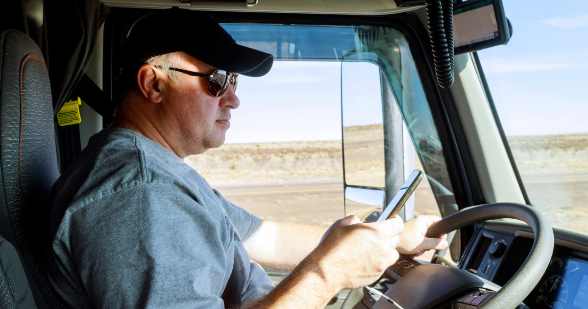 Distracted truck driver looking at his mobile phone