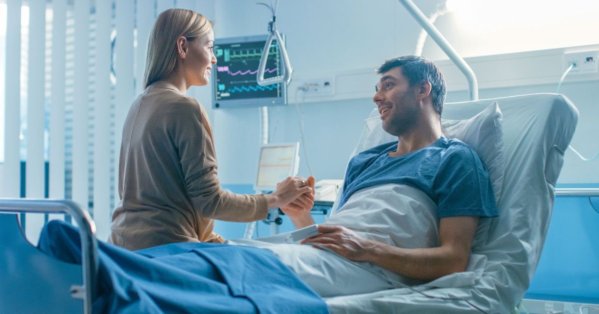 Woman visiting significant other in a hospital bed