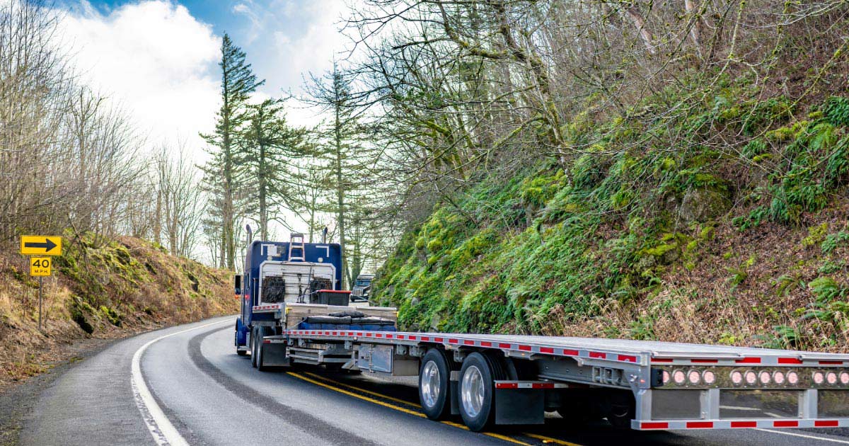 Flatbed truck navigating windy mountain roads