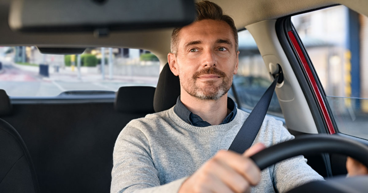 Man driving home from work checking his rearview mirror