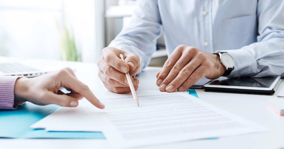 Lawyer reviewing insurance papers and legal documents with client
