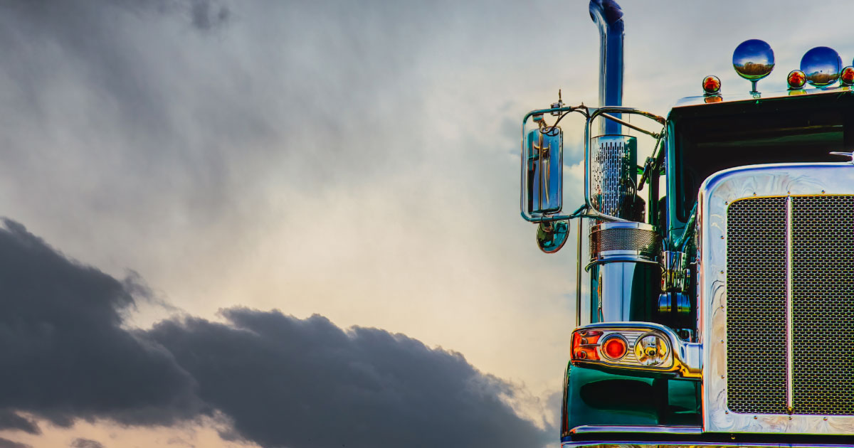 18-wheel diesel truck parked with large tailpipes and spotlights on its roof