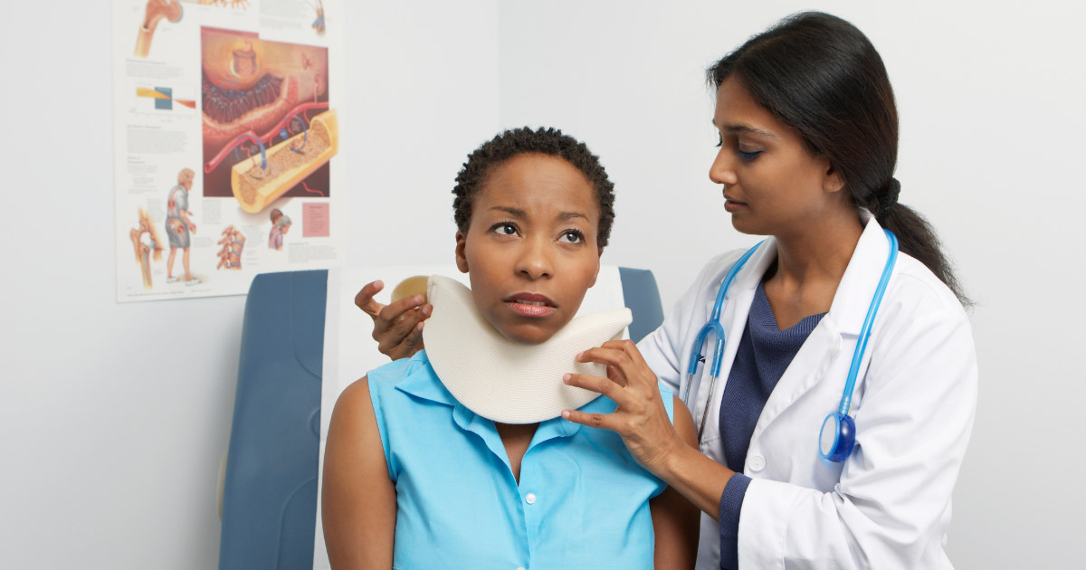 Doctor administering a neck brace to a car accident victim